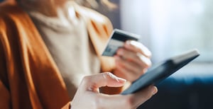 Hands holding a credit card and a mobile phone